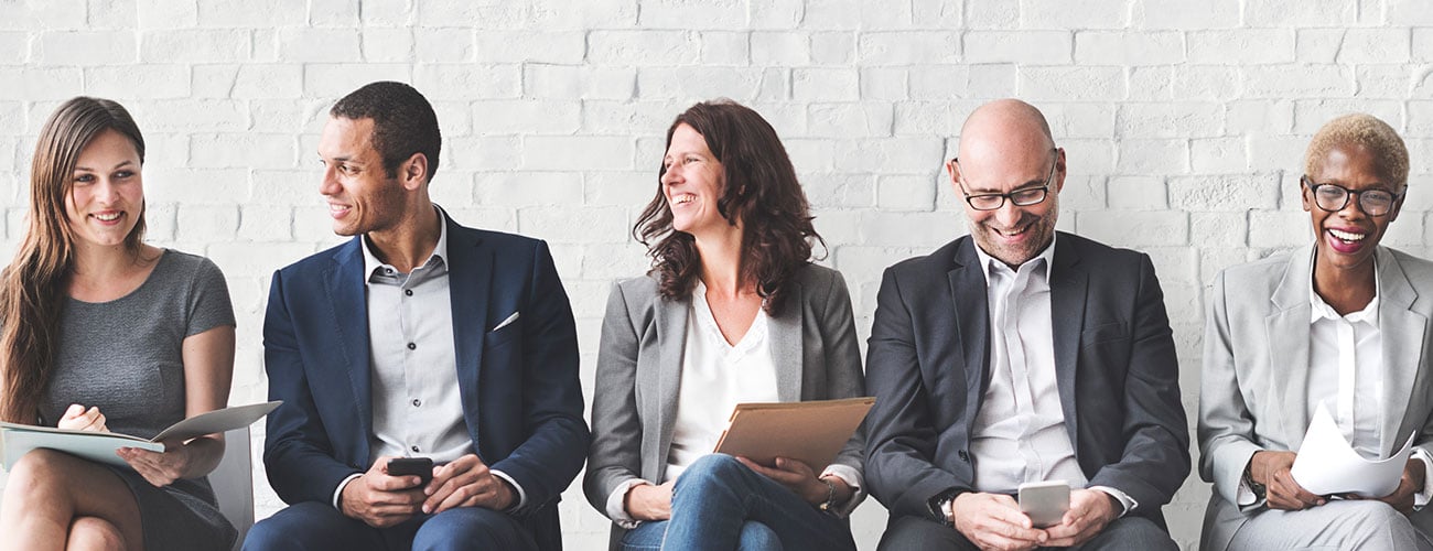 business dressed people sitting along wall